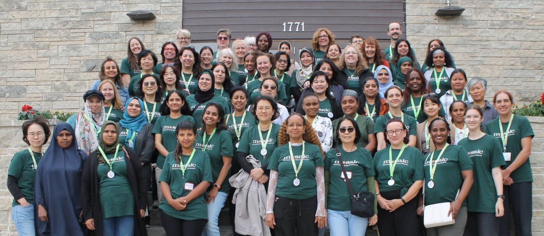 Mosaic all staff picture, united team in Mosaic shirts happily smiling